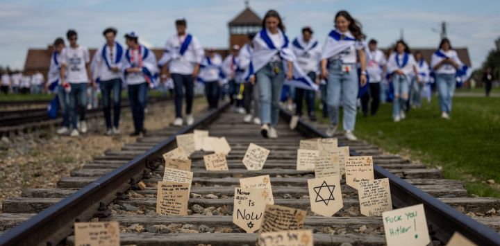 Placas de madera con mensajes y oraciones colocadas por los participantes en una vía férrea que conduce al antiguo campo de exterminio nazi de Auschwitz-Birkenau en Brzezinka, cerca de Auschwitz, Polonia, aparecen fotografiadas durante la Marcha para honrar a las víctimas del Holocausto en el Memorial y Museo Auschwitz II-Birkenau.