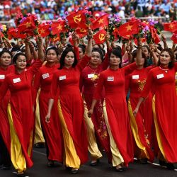 Las mujeres ondean banderas durante las celebraciones oficiales del 70º aniversario de la victoria de Dien Bien Phu en 1954 sobre las fuerzas coloniales francesas en un estadio de la ciudad de Dien Bien Phu, Vietnam. | Foto:NHAC NGUYEN / AFP