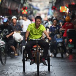Un hombre circula en un triciclo en un mercado en Haikou, en la provincia de Hainan, en el sur de China. | Foto:AFP