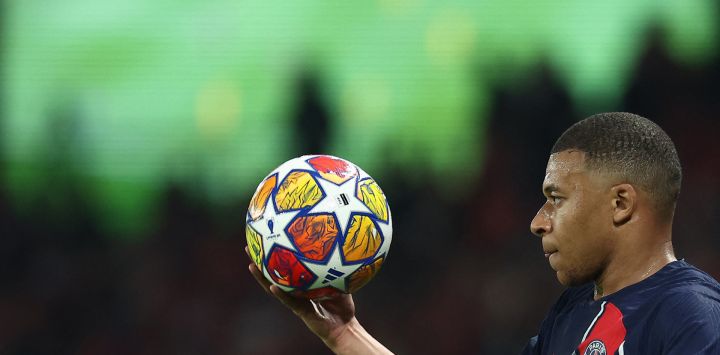 El delantero francés del Paris Saint-Germain, Kylian Mbappe, sostiene el balón durante el partido de fútbol de vuelta de la semifinal de la Liga de Campeones de la UEFA entre el Paris Saint-Germain (PSG) y el Borussia Dortmund, en el estadio Parc des Princes de París.