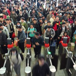 Imagen tomada con un dron de pasajeros cruzando los molinetes en la Estación de Ferrocarriles del Este de Hengyang, en la provincia de Hunan, en el centro de China. | Foto:Xinhua/Cao Zhengping