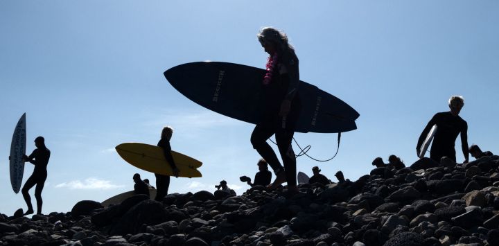 Los surfistas se dirigen al mar para participar en una ceremonia en honor a dos surfistas australianos y un estadounidense que desaparecieron la semana pasada durante un viaje de surf en la playa de San Miguel en Ensenada, estado de Baja California, México.