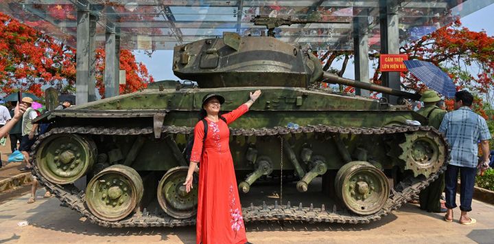 Una mujer vietnamita con un vestido tradicional posa para fotos junto a un tanque francés en la cima del sitio histórico de la batalla de la colina A1 en la ciudad de Dien Bien Phu.