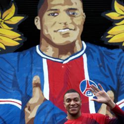 El delantero francés del Paris Saint-Germain, Kylian Mbappé, posa frente a un tifo gigante antes del partido de fútbol francés L1 entre Paris Saint-Germain (PSG) y Toulouse (TFC) en el estadio Parc des Princes de París. | Foto:FRANCK FIFE / AFP