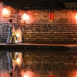 Turistas vestidos con trajes tradicionales son vistos durante una sesión de fotos en la aldea de Hongcun, en la provincia de Anhui, en el este de China. La antigua aldea, ubicada en el condado de Yi en la ciudad de Huangshan, fue agregada a la lista de Sitios del Patrimonio Mundial de la UNESCO en el año 2000 y es conocido por sus vistas panorámicas al lago y su arquitectura tradicional. | Foto:Hector Retamal / AFP