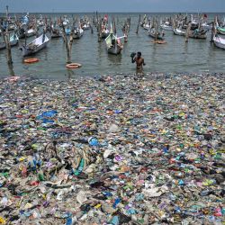 Un pescador regresa a la orilla entre basura en la playa de Bangkalan, isla de Madura, provincia de Java Oriental, Indonesia. | Foto:JUNI KRISWANTO / AFP