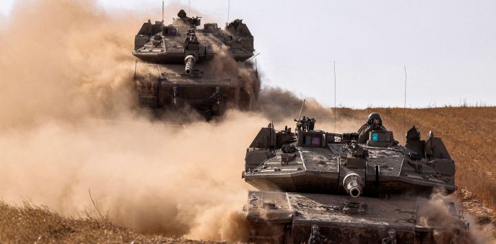 Los tanques de batalla del ejército israelí se mueven cerca de la frontera con la Franja de Gaza en un lugar del sur de Israel, en medio del conflicto en curso en el territorio palestino entre Israel y el movimiento Hamas.