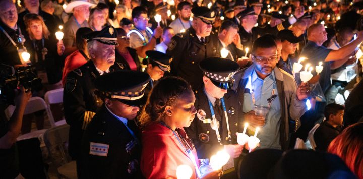 La gente sostiene velas mientras agentes de policía y familiares participan en la 36ª vigilia anual con velas para honrar a los agentes del orden que murieron en el cumplimiento del deber en el National Mall de Washington, DC.