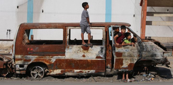 Los niños juegan en una camioneta carbonizada en Rafah, en el sur de la Franja de Gaza, en medio del conflicto en curso entre Israel y el grupo militante Hamás.
