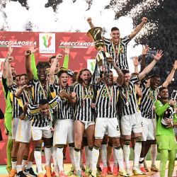 El defensor brasileño de la Juventus Danilo sostiene el trofeo mientras los jugadores de la Juventus celebran después de ganar la final de la Copa de Italia entre Atalanta y Juventus en el estadio olímpico de Roma. | Foto:Isabella Bonotto / AFP