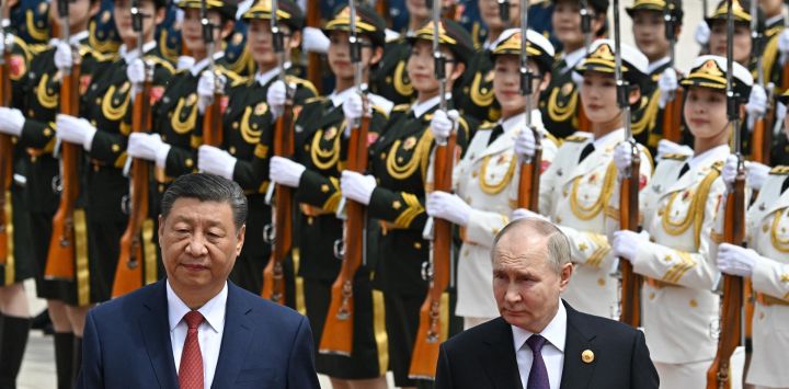 En esta fotografía de piscina distribuida por la agencia estatal rusa Sputnik, el presidente de Rusia, Vladimir Putin, y el presidente de China, Xi Jinping, asisten a una ceremonia oficial de bienvenida frente al Gran Salón del Pueblo en la Plaza de Tiananmen en Beijing.