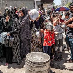 Hombres, mujeres y niños hacen cola para recibir raciones de alimentos en una cocina pública en Deir el-Balah, en el centro de la Franja de Gaza, en medio del conflicto en curso en el territorio palestino entre Israel y Hamás. | Foto:AFP