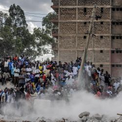 Los transeúntes siguen las operaciones de rescate frente a un edificio derrumbado que estaba siendo demolido en el asentamiento informal Mathare de Nairobi. Varias personas fueron rescatadas después de quedar atrapadas bajo los escombros de un edificio derrumbado que estaba siendo demolido mientras los esfuerzos por llegar otros sospechosos de estar atrapados continuaron, según la Cruz Roja de Kenia. | Foto:LUIS TATO/AFP