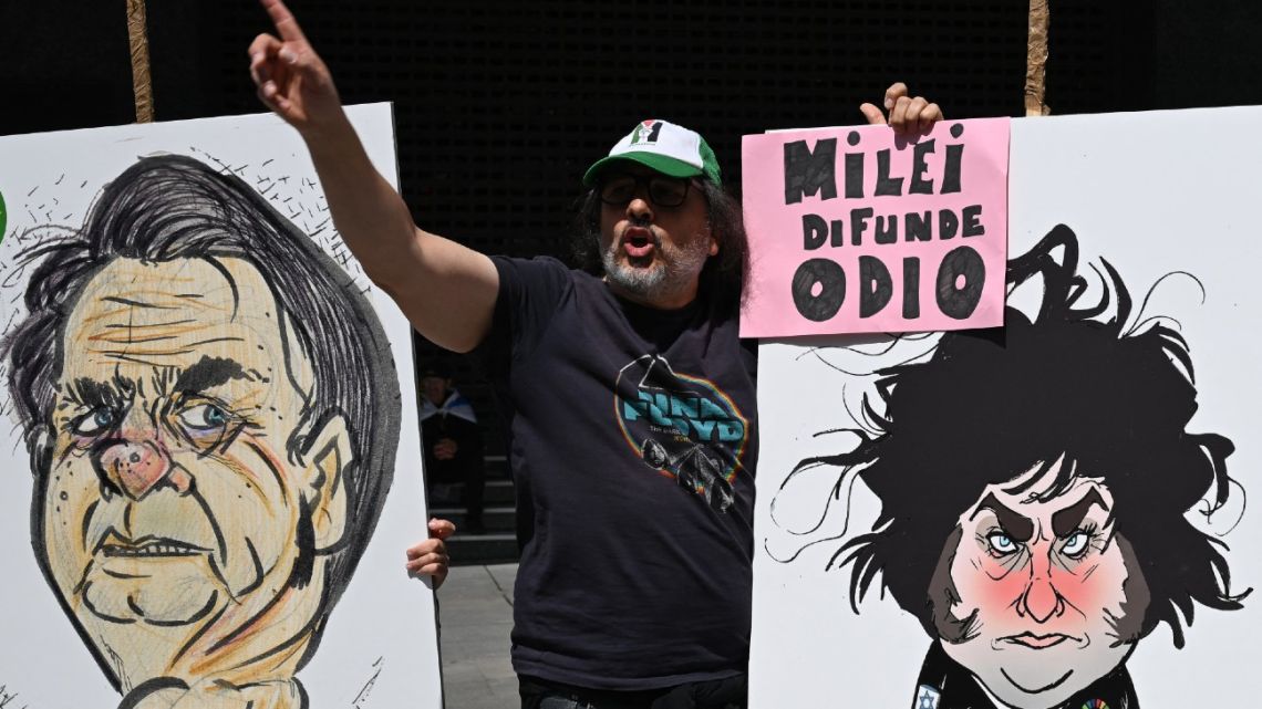 A protestor holds a poster depicting Brazilian President Jair Bolsonaro and Argentine President Javier Milei during an anti far-right demonstration on the eve of a gathering of Spanish far-right party Vox, in Madrid on May 18, 2024. 