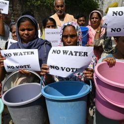 Los residentes sostienen carteles que dicen "Sin agua, no hay voto" y baldes para protestar por el suministro inadecuado de agua en Amritsar, India. | Foto:Narinder Nanu / AFP