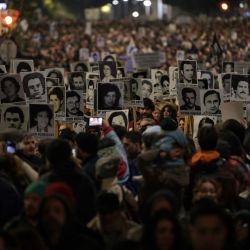 Personas sostienen retratos de los desaparecidos durante la última dictadura (1973-1985) en Uruguay durante la Marcha del Silencio en Montevideo. | Foto:EITAN ABRAMOVICH / AFP