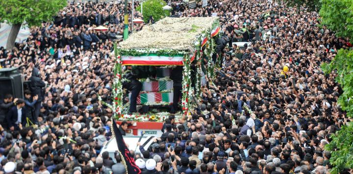 La gente participa en una procesión fúnebre junto a un camión que transporta los ataúdes del presidente Ebrahim Raisi y sus siete ayudantes en Tabriz, provincia de Azerbaiyán Oriental, murieron en un accidente de helicóptero en la ladera de una montaña cubierta de niebla en el noroeste.