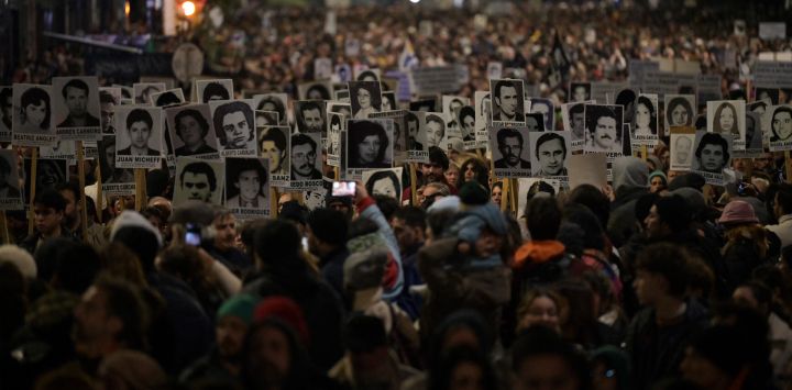 Personas sostienen retratos de los desaparecidos durante la última dictadura (1973-1985) en Uruguay durante la Marcha del Silencio en Montevideo.
