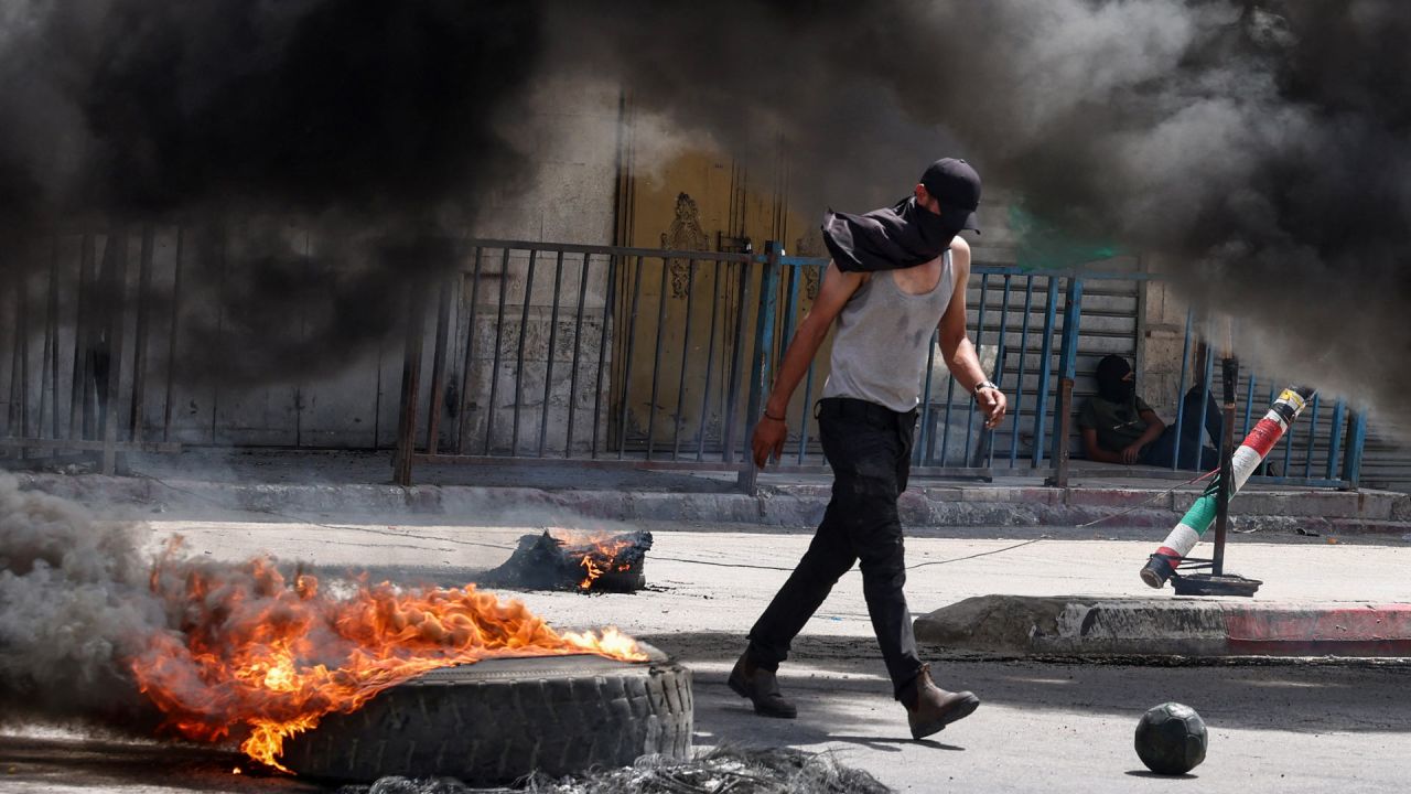 El humo surge de la quema de neumáticos en medio de enfrentamientos entre manifestantes palestinos y fuerzas israelíes que realizaban una redada en Jenin, en la ocupada Cisjordania. | Foto:ZAIN JAAFAR / AFP