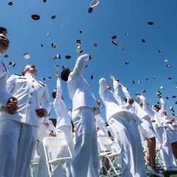 Los cadetes lanzan sus viejos sombreros al aire mientras se realiza un sobrevuelo durante la desinversión de símbolos para convertirse oficialmente en oficiales de la Guardia Costera durante los 143 ejercicios de graduación de la Guardia Costera de los EE. UU. en la Academia de la Guardia Costera de los EE. UU. en New London, Connecticut. Aproximadamente 220 cadetes estadounidenses recibieron sus comisiones y títulos universitarios. | Foto:JOSÉ PREZIOSO / AFP
