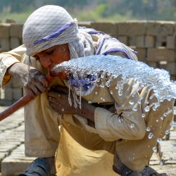Un trabajador bebe agua de una tubería en un horno de ladrillos en un caluroso día de verano en Sukkur, provincia de Sindh. El Departamento Meteorológico de Pakistán dijo que se espera que las temperaturas alcancen los 50 grados Celsius (122 grados Fahrenheit) en algunas de las zonas rurales de Sindh. | Foto:Shahid Ali / AFP