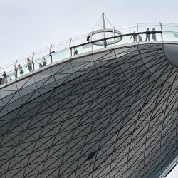 La gente se encuentra en la plataforma de observación del hotel Marina Bay Sands en Singapur. | Foto:Roslan Rahman / AFP