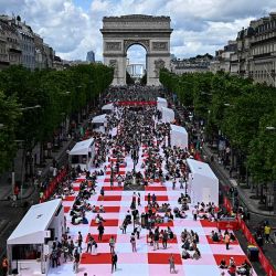 La gente participa en un picnic gigante al aire libre en la avenida de los Campos Elíseos de París. Unas 4.000 personas fueron seleccionadas para almorzar sobre una alfombra "la alfombra del mundo". Foto JULIEN DE ROSA / AFP | Foto:AFP