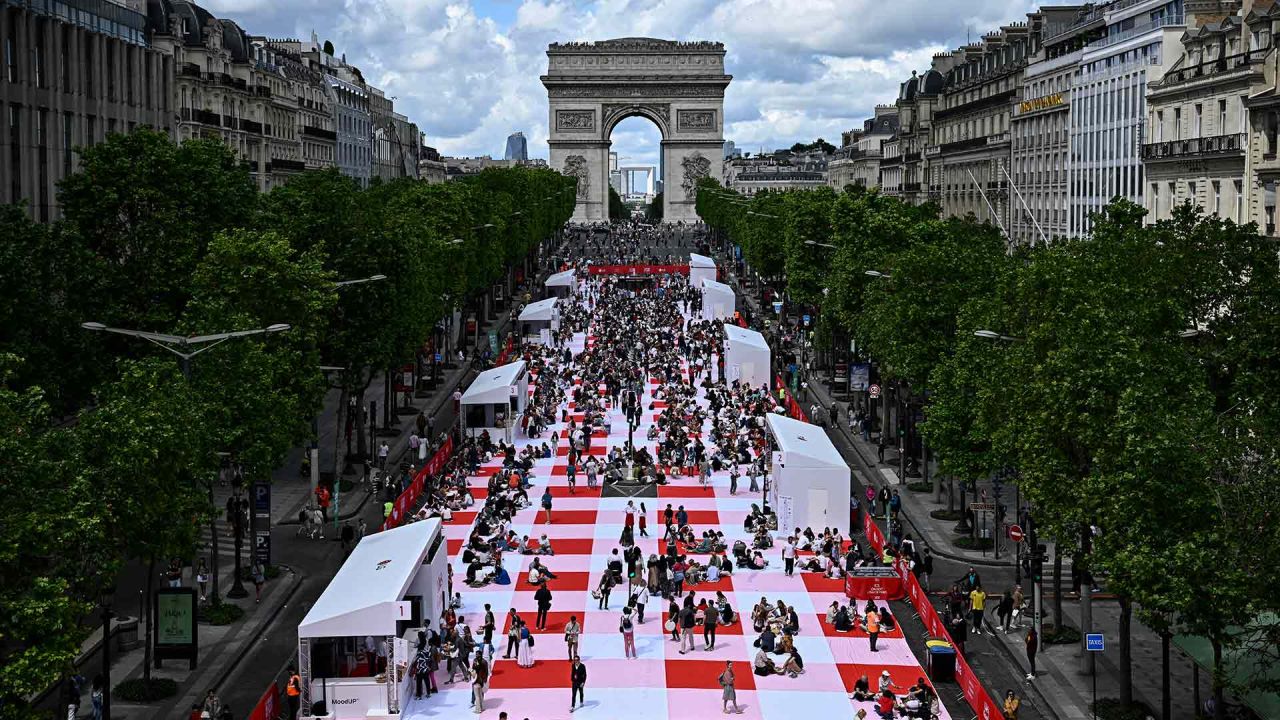 La gente participa en un picnic gigante al aire libre en la avenida de los Campos Elíseos de París. Unas 4.000 personas fueron seleccionadas para almorzar sobre una alfombra "la alfombra del mundo". Foto JULIEN DE ROSA / AFP | Foto:AFP