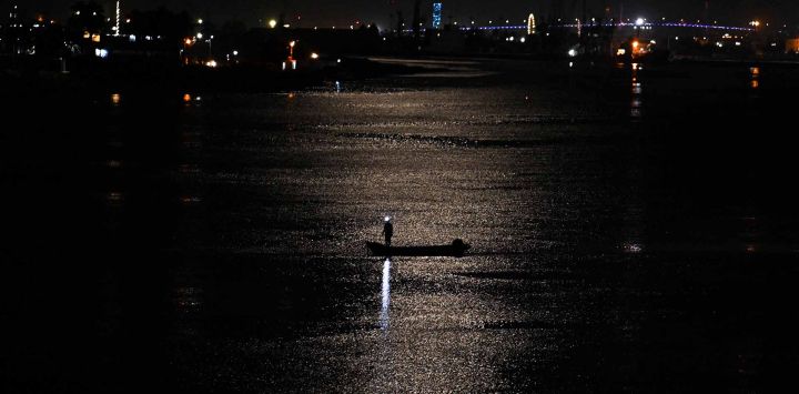 Los pescadores que trabajan en un barco por la noche se recortan a la luz de la luna en el río Shatt al-Arab, formado en la confluencia de los ríos Tigris y Éufrates, en la ciudad de Basora, en el sur de Irak. Foto Hussein FALEH / AFP