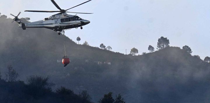 Un helicóptero de rescate que transportaba agua se prepara para extinguir un incendio que estalló en el bosque de Margalla Hills debido al aumento de las temperaturas. Foto Aamir QURESHI / AFP