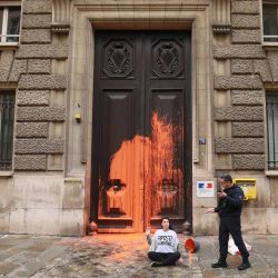 La policía francesa frente a una activista del grupo ambientalista (Represalias contra los alimentos) después de que arrojó un cubo de pintura naranja contra la puerta del Ministerio de Agricultura francés. Foto Sami KARAALI / AFP | Foto:AFP