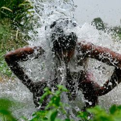 Un hombre se ducha bajo el agua que sale de una tubería a lo largo de las llanuras aluviales de Yamuna en una calurosa tarde de verano en Nueva Delhi. Foto Arun SANKAR / AFP | Foto:AFP