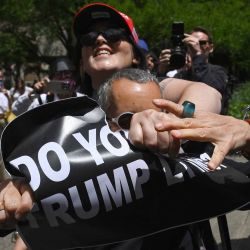 Un manifestante anti-Trump y un partidario pro-Trump se pelean por un cartel durante una disputa mientras esperan un veredicto del candidato presidencial republicano Donald Trump. Foto ANGELA WEISS / AFP | Foto:AFP