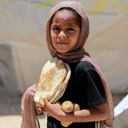 Una niña palestina carga pan y patatas en un campamento para personas desplazadas en Deir al-Balah, en el centro de la Franja de Gaza. Foto Bashar TALEB / AFP | Foto:AFP