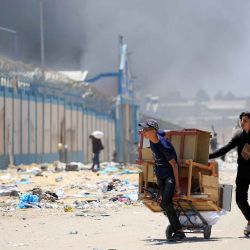 Los palestinos huyen con sus pertenencias mientras se eleva humo al fondo, en la zona de Tel al-Sultan en Rafah. Foto Eyad BABA / AFP | Foto:AFP