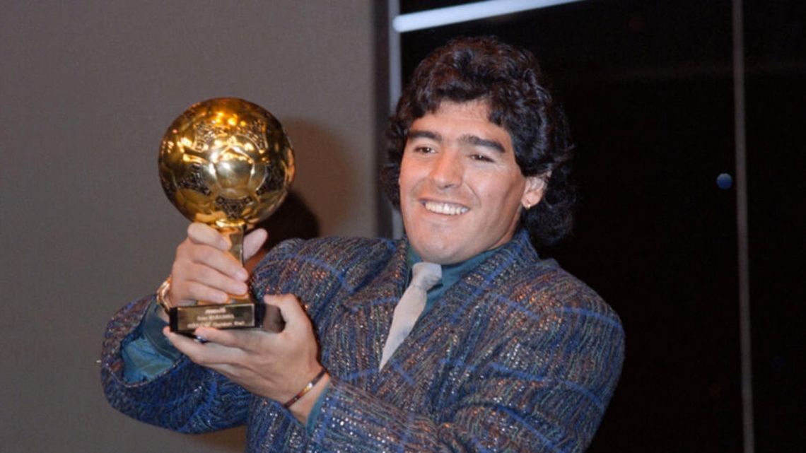Diego Maradona poses with the 1986 World Cup 'Golden Ball' trophy at the Lido in Paris on November 13, 1986.