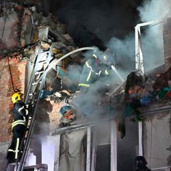 Los rescatistas extinguen un incendio en un edificio de apartamentos destruido por un ataque con misiles rusos en Kharkiv. Foto SERGEY BOBOK / AFP | Foto:AFP