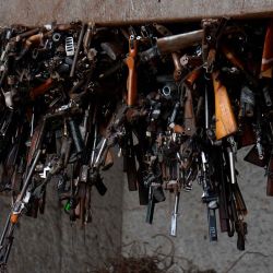 Un imán sostiene armas confiscadas en operaciones policiales durante su destrucción por las fuerzas armadas ecuatorianas, en Guayaquil, Ecuador. Foto Gerardo MENOSCAL / AFP | Foto:AFP