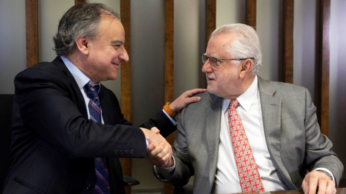 This handout picture released by Codelco shows Codelco's President Maximo Pacheco (R) and SQM's President Ricardo Ramos shaking hands after signing an agreement in Santiago on May 31, 2024. Chile's state-owned Codelco, the world's largest copper producer, and SQM, one of the world's leading lithium producers, sealed an agreement on Friday to create a giant company to exploit lithium, a key metal for the energy transition. 