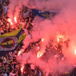 Los seguidores del Fenerbahce encienden bengalas de humo durante la presentación de su nuevo entrenador José Mourinho en el estadio Sukru Saracoglu de Estambul. | Foto:Yasin Akgul / AFP
