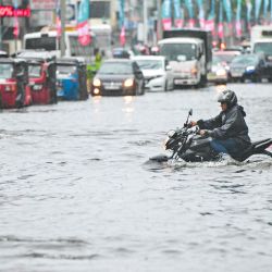 Un hombre conduce una motocicleta por una calle inundada después de fuertes lluvias en Colombo. Inundaciones repentinas, deslizamientos de tierra y caídas de árboles han matado al menos a 14 personas en Sri Lanka mientras la nación isleña es azotada por tormentas monzónicas. | Foto:ISHARA S. KODIKARA / AFP