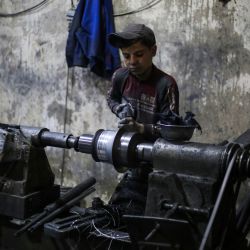 Un niño trabaja en una fábrica de utensilios de cocina de aluminio en Al-Bab, en las afueras de Alepo, Siria. | Foto:Aaref Watad / AFP