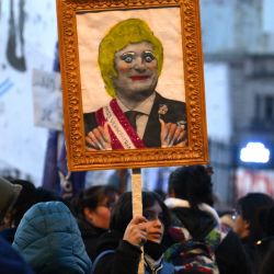 Una mujer sostiene una fotografía del presidente argentino Javier Milei durante la novena marcha de "Ni una menos" denunciando el alto número de feminicidios y violencia de género y contra las políticas económicas y de reforma estatal del presidente Javier Milei, frente a la Asamblea Nacional. Congreso en Buenos Aires. | Foto:LUIS ROBAYO / AFP