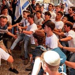 Activistas de derecha israelíes se pelean con el periodista independiente palestino Saif Kwasmi durante la llamada marcha de la bandera del Día de Jerusalén. | Foto:HAZEM BADER / AFP