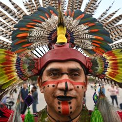 Un hombre viste un traje tradicional para participar en un ritual azteca en la Plaza del Zócalo de la Ciudad de México. | Foto:PEDRO PARDO / AFP