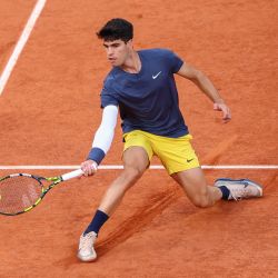 El español Carlos Alcaraz Garfia regresa al griego Stefanos Tsitsipas durante su partido de cuartos de final masculino en la cancha Philippe-Chatrier el décimo día del torneo de tenis del Abierto de Francia en el complejo Roland Garros de París. | Foto:Emmanuel Dunand/AFP