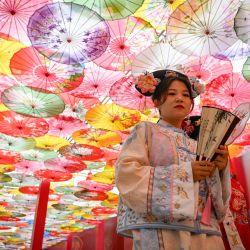 Una mujer vestida con ropa tradicional visita una calle comercial en Beijing, China. | Foto:Wang Zhao / AFP