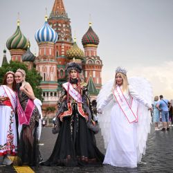 Mujeres disfrazadas posan para una fotografía en la Plaza Roja cerca de la Catedral de San Basilio en Moscú. | Foto:NATALIA KOLESNIKOVA / AFP