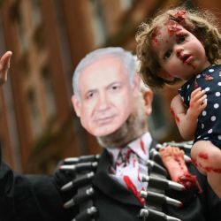 Un manifestante con una máscara que representa al primer ministro de Israel, Benjamin Netanyahou, sostiene un muñeco cubierto de pintura roja, durante una "Marcha Nacional por Gaza", en el centro de Londres, pidiendo "poner fin al genocidio" y "dejar de armar a Israel". | Foto:JUSTIN TALLIS / AFP