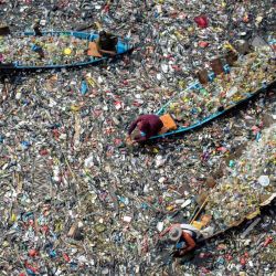 Personas en barcos recogen plásticos reciclables del río Citarum, muy contaminado, en Batujajar, Bandung, Java Occidental, Indonesia. | Foto:TIMUR MATAHARI / AFP